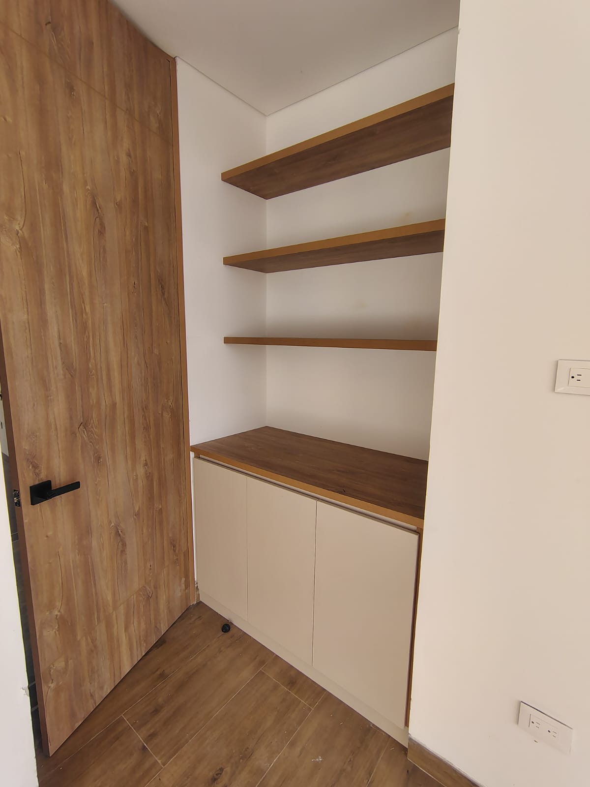Nicho a medida con repisas en madera, mueble bajo y puerta enchapada
