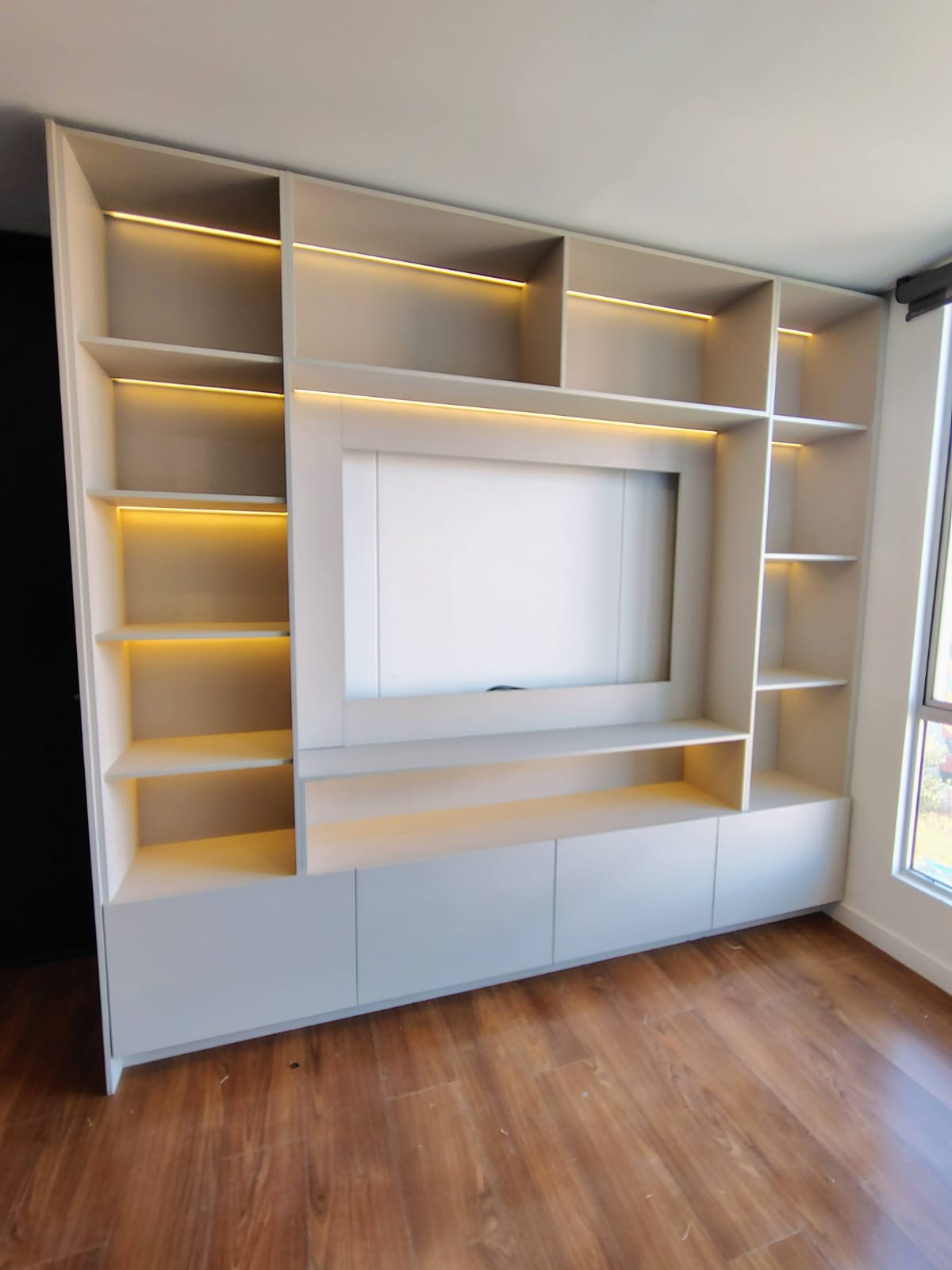 Mueble de TV con biblioteca integrada e iluminación LED en cada entrepaño