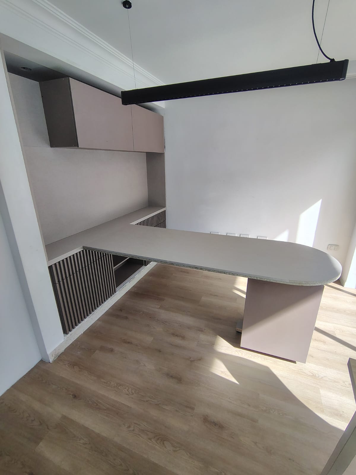 Escritorio de oficina a medida con superficie curva y muebles aéreos