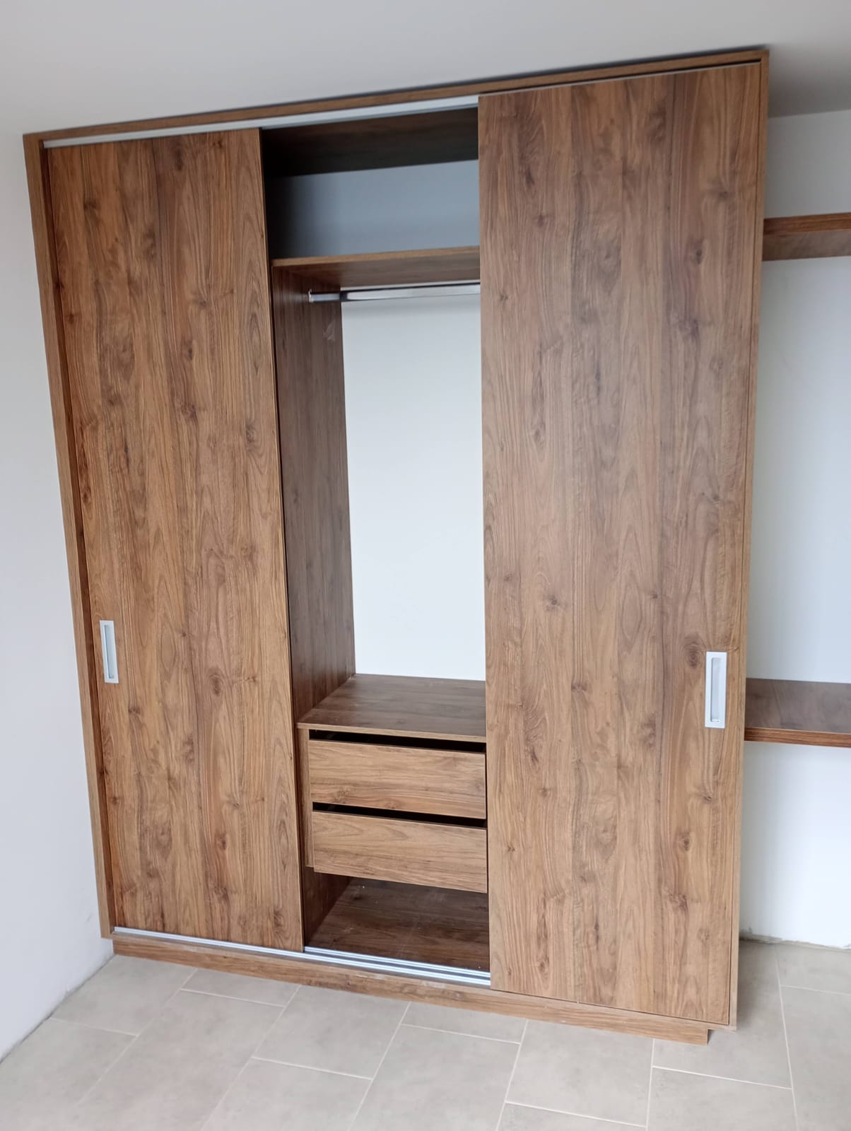 Clóset corredizo en madera con barra, cajones y entrepaños internos